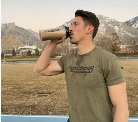 An athlete drinking chickpea protein shake from a sports formula shaker bottle.