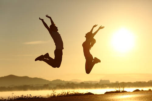 They are expressing their surge of energy by jumping into the air with pure joy and excitement, their faces glowing with enthusiasm. 