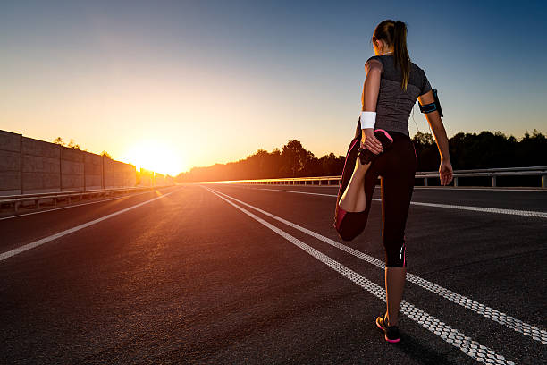 A woman holding her left foot while exercising.