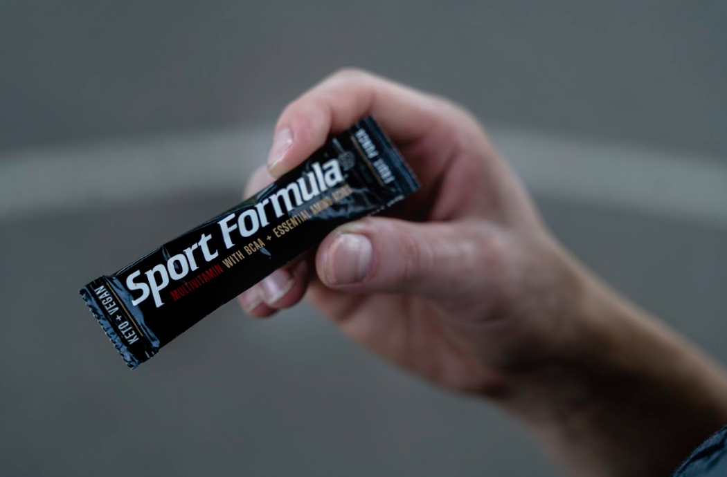 Holding a single piece of multivitamin packet.