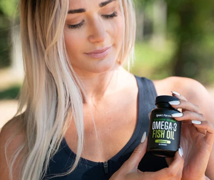 A woman holding Omega-3 fish oil.