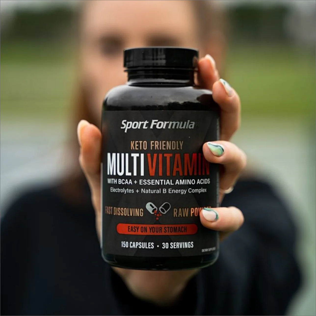 A person holds a container of keto-friendly multivitamins, highlighting features like BCAA, electrolytes, and 150 capsules.