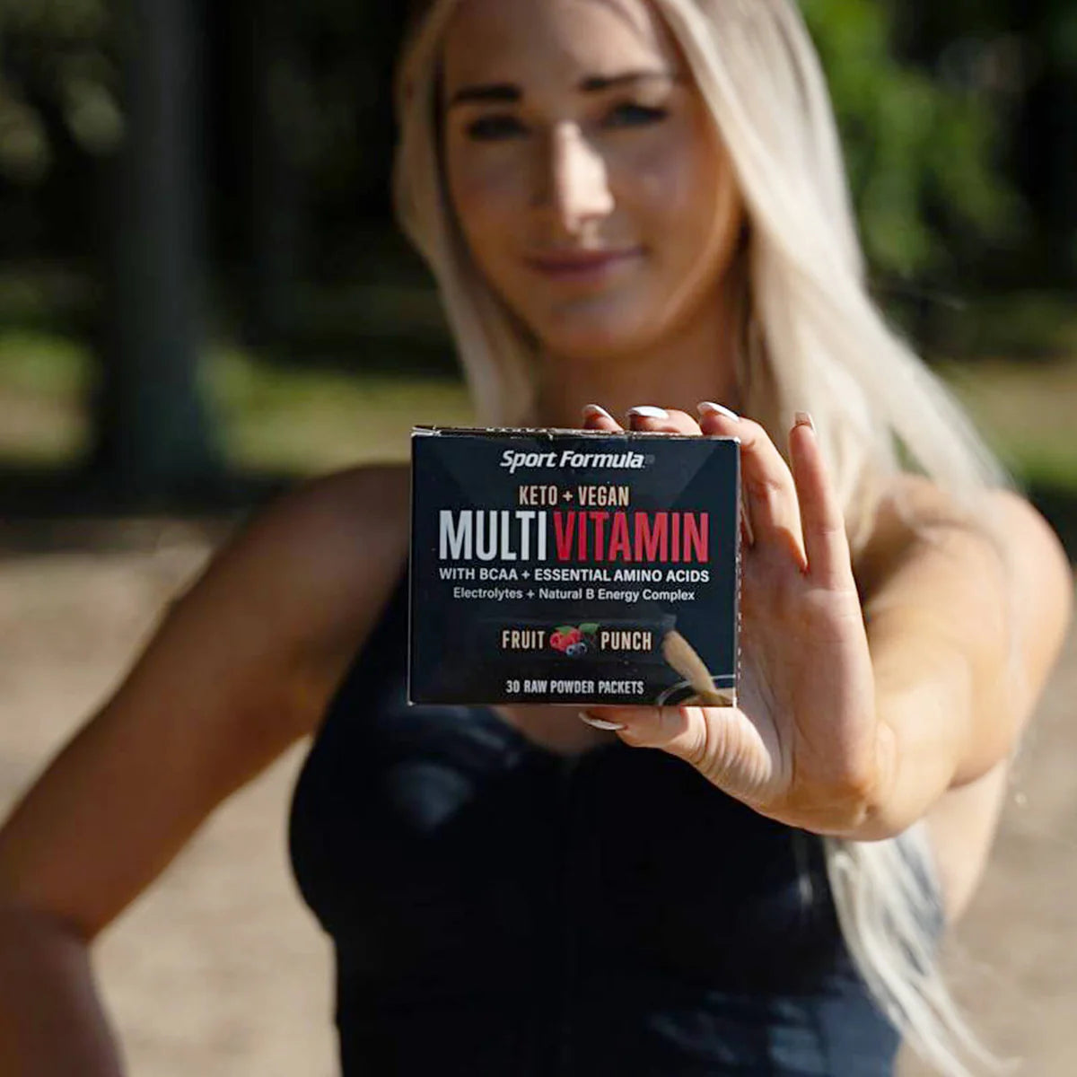 Multivitamin packets held by a woman in the background