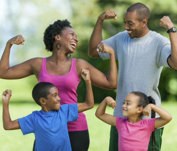 A joyful and smiling family, standing together with their arms raised in unity, promoting a sense of strength, happiness, and togetherness. Their posture symbolizes a shared commitment to living a healthy and active lifestyle.