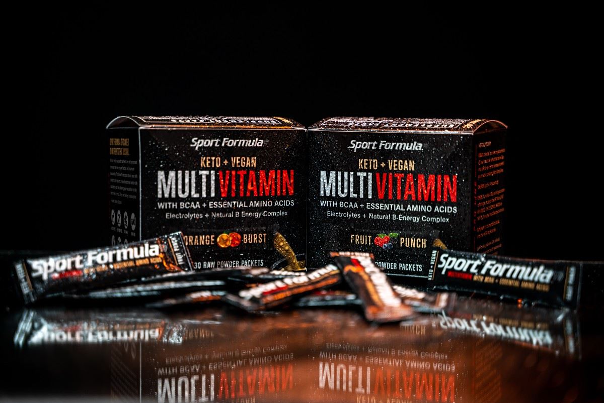 Sport Formula's Keto Vegan Multivitamins in two flavors, Orange Burst and Fruit Punch, with BCAAs and essential amino acids packets.