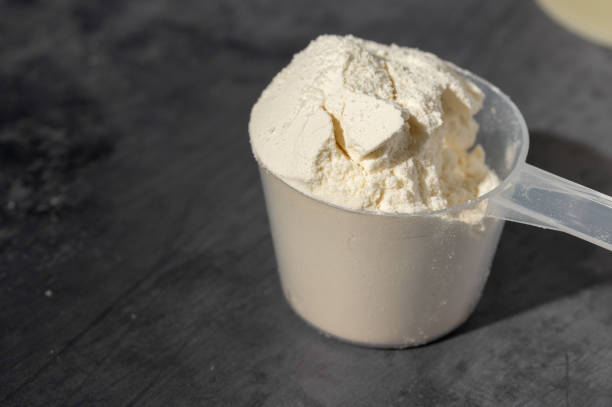 Close-up of a scoop filled with powdered vitamins, highlighting health benefits such as supporting immune function, improving energy levels, and promoting overall wellness.